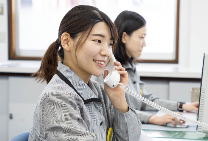 電話を受けている総務課の笠井奈留美